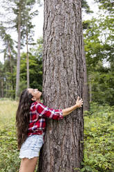 Woman hugging tree looking up at Cannock Chase - WPEF05672