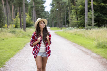 Thoughtful woman walking on road at Cannock Chase - WPEF05679