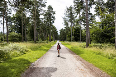 Frau steht auf der Straße im Wald bei Cannock Chase - WPEF05680