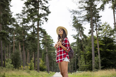 Lächelnde Frau mit Blick nach oben, stehend in Cannock Chase - WPEF05681