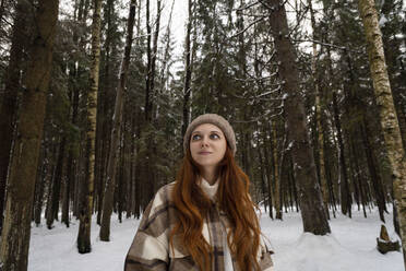 Woman on vacation day dreaming in winter forest - SSGF00390