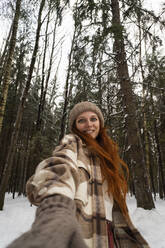 Lächelnde Frau im Winterwald im Urlaub - SSGF00395