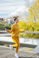 Young athlete skipping rope on bridge - PGF00994