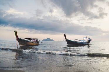 Longtail boats moored in sea at Ao Nang beach, Krabi Province, Thailand - CHPF00830