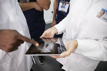 Mitarbeiter des Gesundheitswesens diskutieren am Tablet-PC im Krankenhaus - PMF02142
