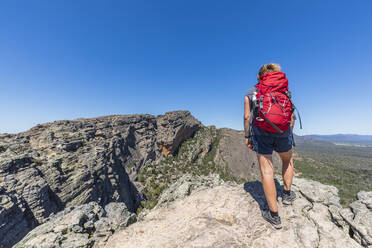 Australia, Victoria, Female tourist admiring view from summit of Hollow Mountain - FOF12654