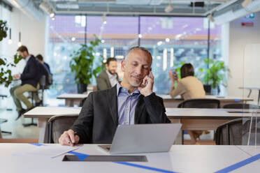 Businessman working over laptop at office - EIF03057