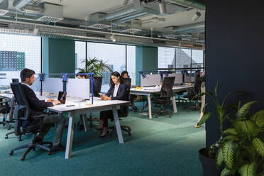 Geschäftsleute arbeiten an einem Schreibtisch in einem Coworking Space - EIF03083