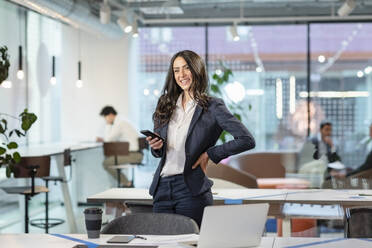 Cheerful manager with smart phone in office - EIF03125