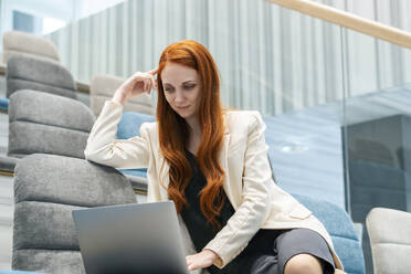 Businesswoman using laptop at office auditorium - SSGF00449