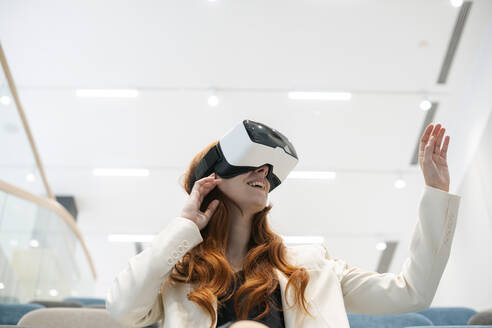 Lächelnde Geschäftsfrau mit Virtual-Reality-Headset im Hörsaal - SSGF00456