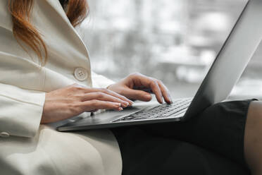 Hands of working woman typing on laptop in office - SSGF00463