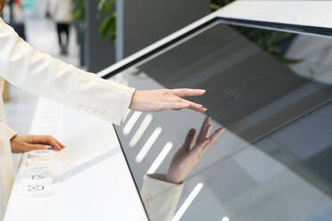 Geschäftsfrau verwendet Touchscreen-Gerät im Büro - SSGF00478