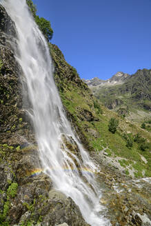 Regenbogen über einem Wasserfall auf einem Berg an der Cascade de Sillans, Sillans-la-Cascade, Nationalpark Ecrins, Frankreich - ANSF00154