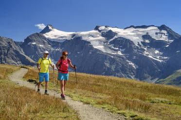 Wanderfreunde beim Wandern mit Wanderstock auf Bergbahn im Winterurlaub, Nationalpark Vanoise, Frankreich - ANSF00199