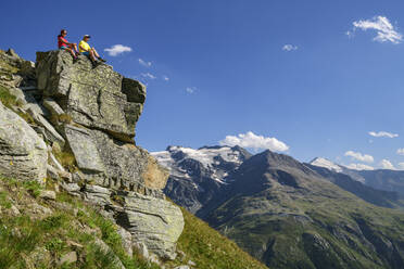 Wanderer, die an einem sonnigen Tag auf einer Klippe sitzen Vanoise-Massiv, Vanoise-Nationalpark, Frankreich - ANSF00201