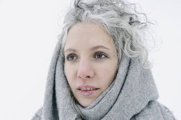Nachdenkliche Frau mit Schnee auf den Lippen, eingewickelt in einen grauen Schal - SEAF00392