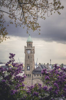 Deutschland, Hamburg, Uhrenturm an den St. Pauli Piers mit blühenden Blumen im Vordergrund - KEBF02154