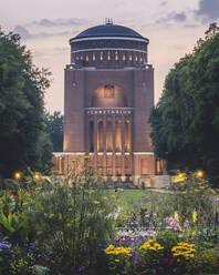 Germany, Hamburg, Colorful flowers blooming in front of Hamburg Planetarium at dusk - KEBF02172