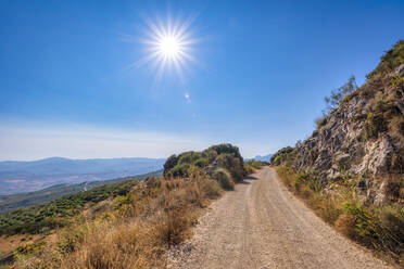 Leere Schotterstraße am Berg an einem sonnigen Tag in Andalusien, Spanien, Europa - SMAF02067