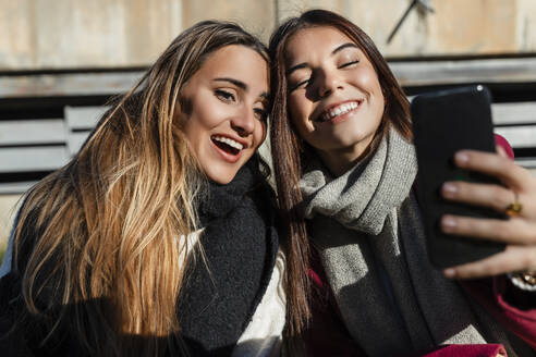 Glückliche Freunde nehmen Selfie zusammen durch Smartphone auf sonnigen Tag - JRVF02490