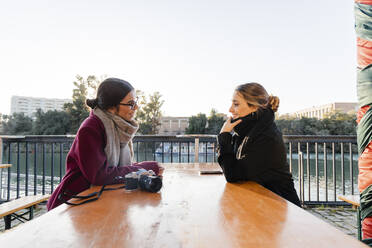 Junge Freunde sitzen und reden in einem Straßencafé - JRVF02496