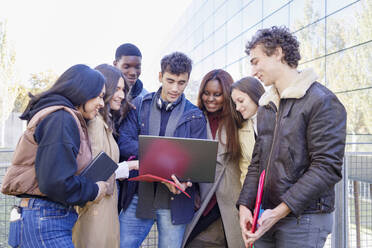 Gemischtrassige Freunde studieren gemeinsam am Laptop auf dem Campus - IFRF01406