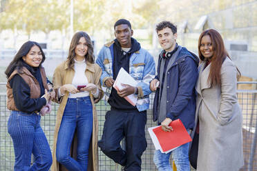 Lächelnde multirassische Studenten, die auf dem Universitätscampus zusammenstehen - IFRF01422