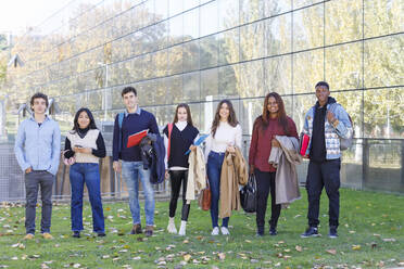 Lächelnde Freunde stehen auf dem Rasen einer Universität - IFRF01428