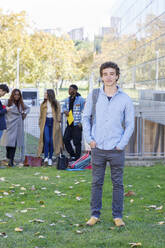Junger Mann mit Studenten im Hintergrund auf dem Universitätscampus - IFRF01447