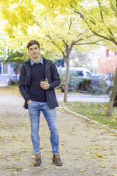 Young man with hand in pocket at college park - IFRF01480