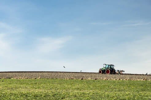 Traktor auf einem Feld unter blauem Himmel - WFF00550