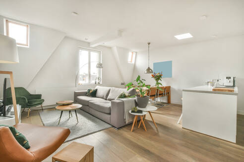 Offener Raum mit Wohnzimmer mit bequemem Sofa und Küche mit Insel und Esszimmer mit Holztisch - ADSF33294