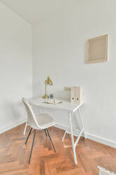 Table with notebook near lamps in light spacious room in modern apartment - ADSF33325