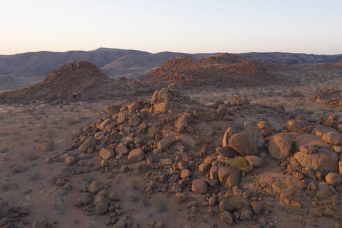 Luftaufnahme der Wüste mit Felsformationen bei Sonnenuntergang im Mowani Mountain Camp, Namibia. - AAEF13619