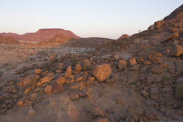 Luftaufnahme einer Person, die auf einem Felsbrocken in der Namib-Wüste, Namibia, steht. - AAEF13622