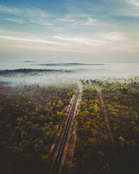 Luftaufnahme einer Straße mit nebliger Landschaft in Australien, in den Northern Territories. - AAEF13713