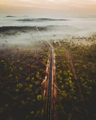 Luftaufnahme einer Straße mit nebliger Landschaft in Australien, in den Northern Territories. - AAEF13714