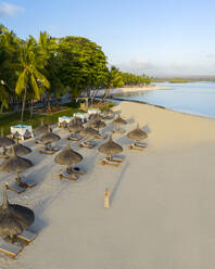 Luftaufnahme einer Frau beim Spaziergang am Strand von Poste de Flacq, Mauritius. - AAEF13802