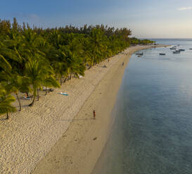 Luftaufnahme einer schönen Frau, die am Strand von Le Morne, Le Morne, Mauritius, spazieren geht. - AAEF13842