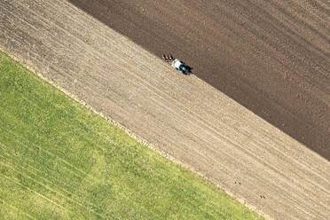 Aerial view of tractor plowing field on sunny day - WFF00551