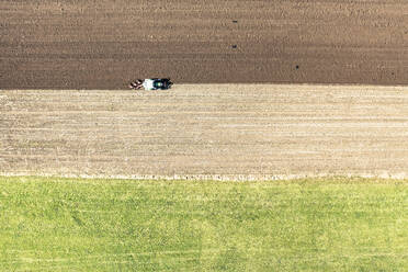 Drohnenansicht eines Traktors beim Pflügen eines Feldes an einem sonnigen Tag - WFF00552