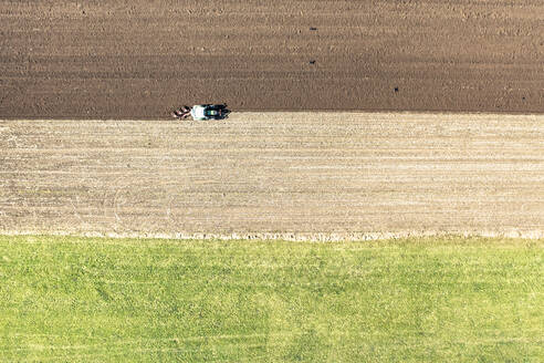 Drohnenansicht eines Traktors beim Pflügen eines Feldes an einem sonnigen Tag - WFF00552