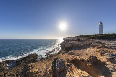 Australien, Victoria, Die Sonne scheint über der rauen Küste des Cape Nelson State Park mit dem Cape Nelson Lighthouse im Hintergrund - FOF12680