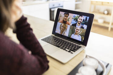 Freelancer doing video call with colleagues on laptop at home - XLGF02563