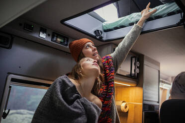 Friends looking at bed in motor home - MRRF01843
