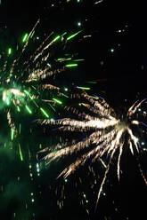 Grüne und gelbe Feuerwerkskörper explodieren am klaren Nachthimmel - JTF01972