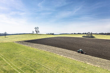 Luftaufnahme eines Traktors beim Pflügen eines Feldes im Frühjahr - WFF00572