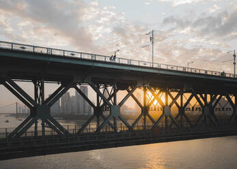 Luftaufnahme von Menschen, die den Sonnenuntergang von einer Brücke in Wuhan, China, beobachten. - AAEF13924