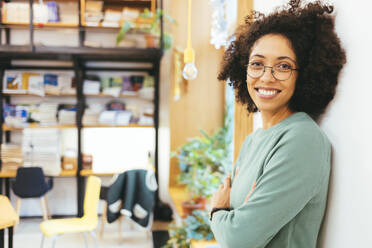 Smiling businesswoman with arms crossed in creative office - OYF00664